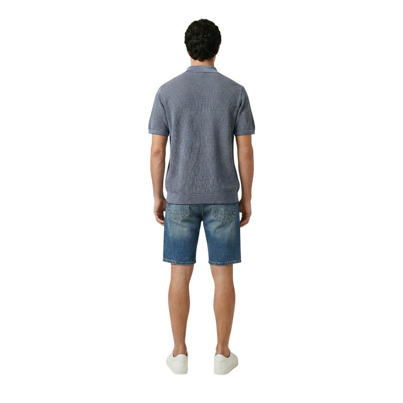 Back view of a man wearing a blue polo shirt featuring short sleeves and a collar on a white background.