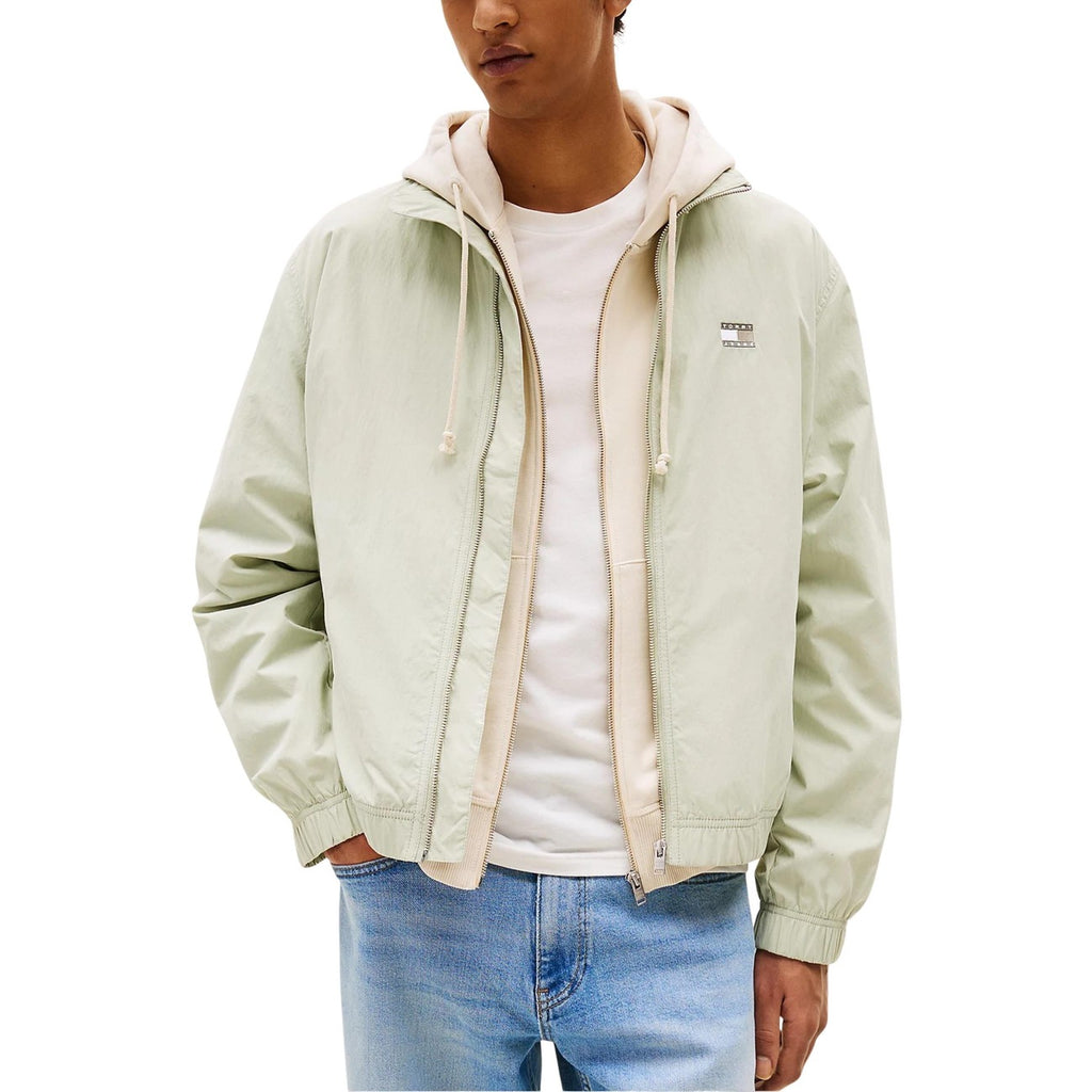Lifestyle shot of a light green hooded jacket with zipper closure against a white background
