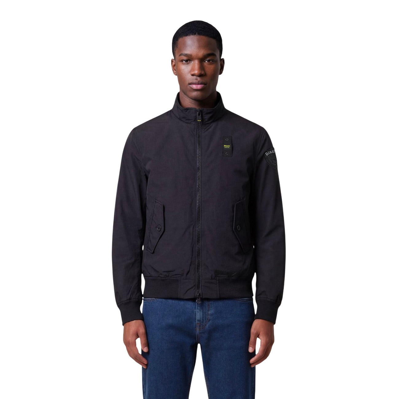 Lifestyle shot of a model wearing the black blazer with zipper closure and pockets on a white background.