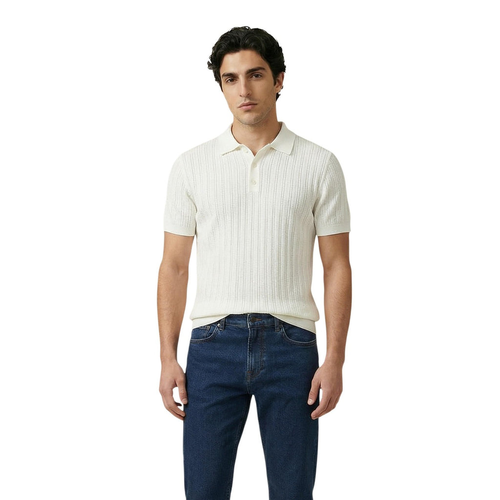Lifestyle shot of a man wearing a white polo shirt with short sleeves and a collar.