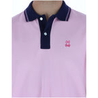 Close-up detail of the pink polo shirt collar with buttons and logo.