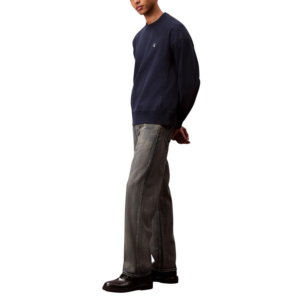 Back view of beige Calvin Klein Jeans featuring straight leg and pockets on a white background