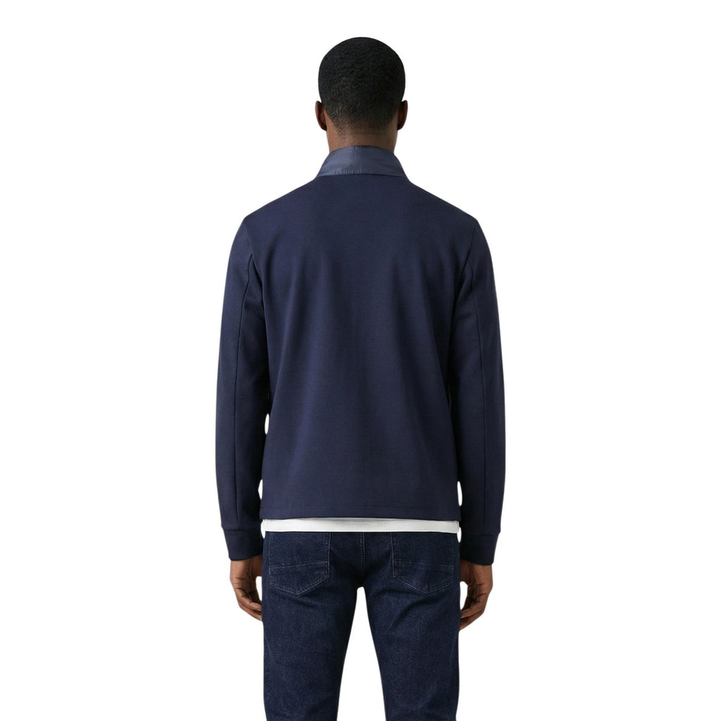 Front view of the navy puffer jacket paired with pants, highlighting the zipper closure and quilted design.