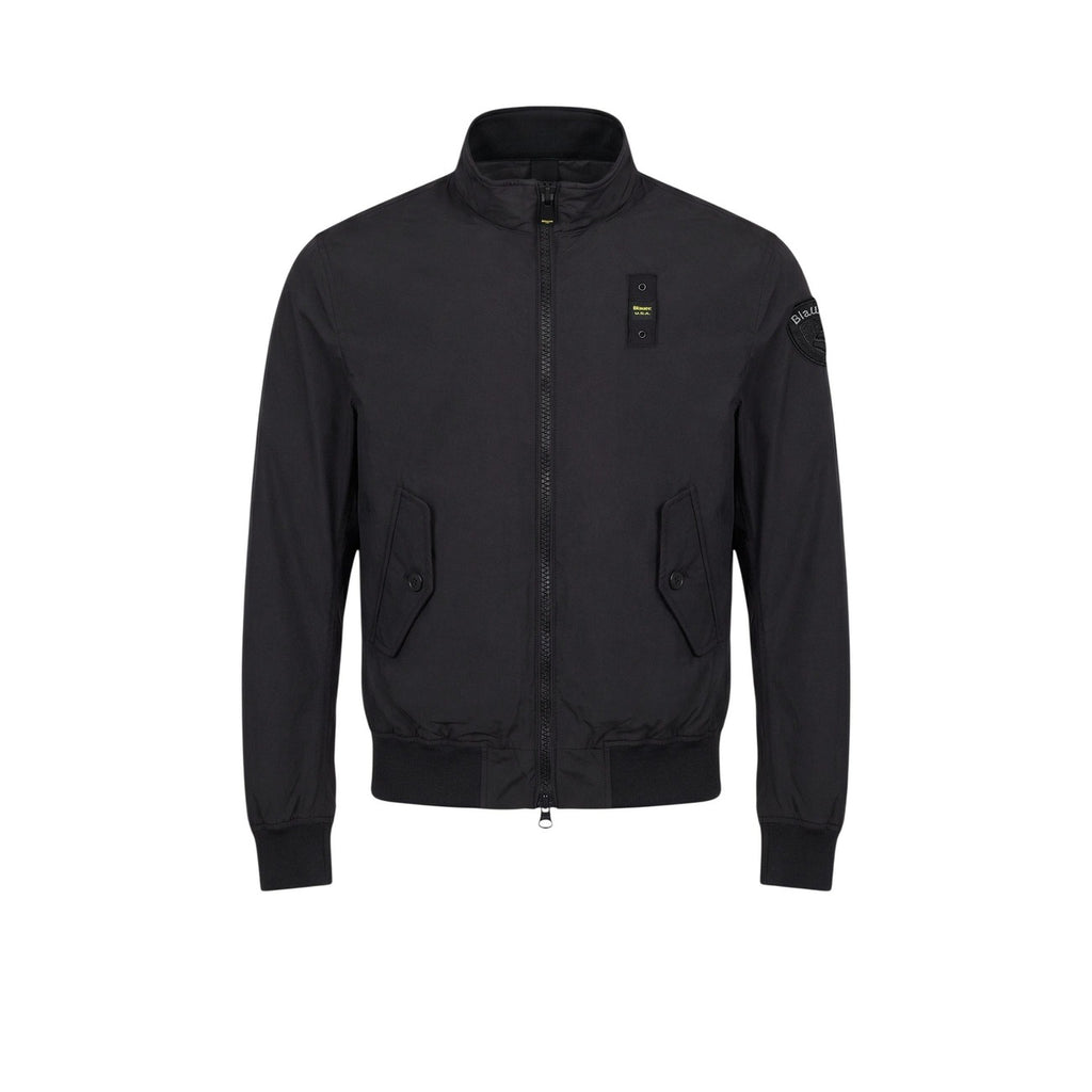 Front view of the black blazer featuring zipper closure and pockets against a white background.