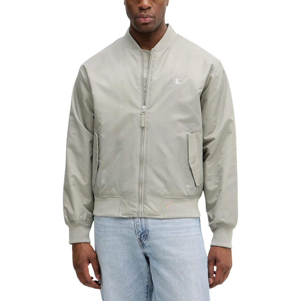 Detail close-up of the green blazer with zipper closure on a white background
