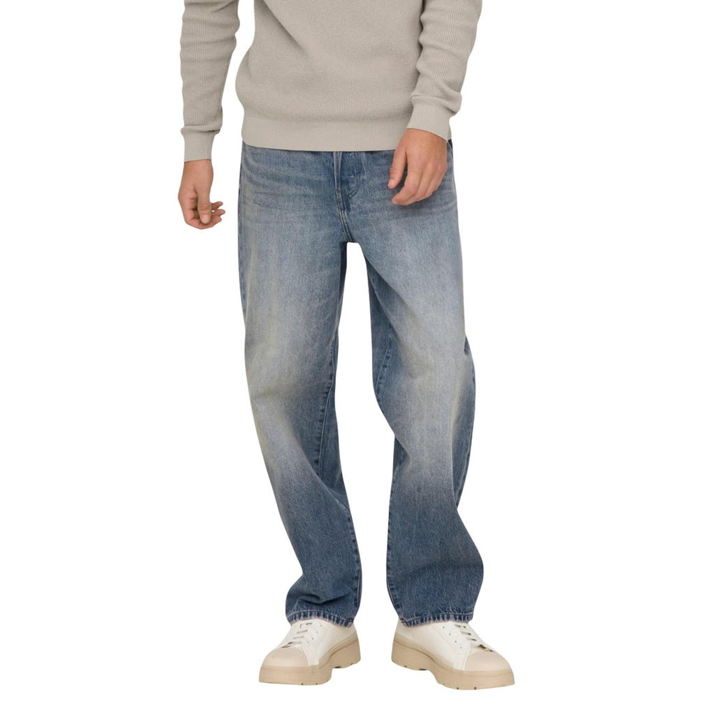 Lifestyle shot of a man in light blue faded denim jeans, loose fit, on a white background.