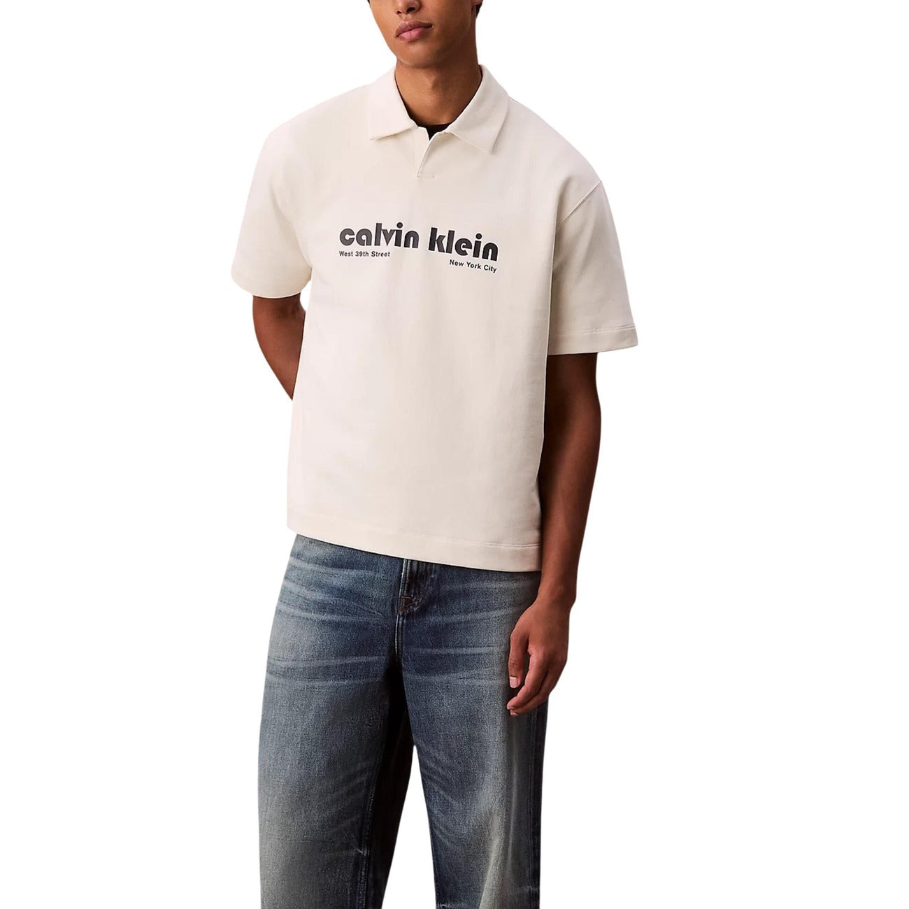Lifestyle shot of a beige polo shirt with logo print and short sleeves against a white background.
