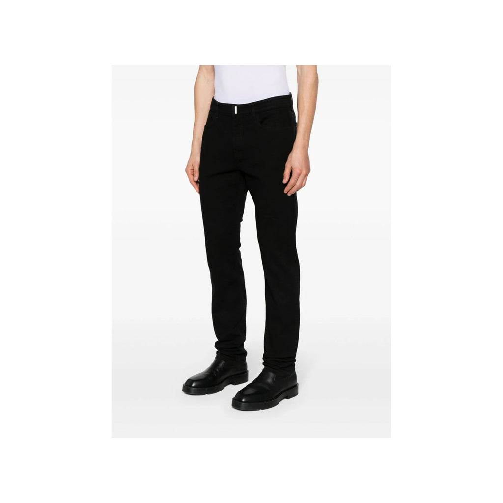 Lifestyle shot of black Givenchy men's jeans showcasing a casual style with flared legs on a white background.