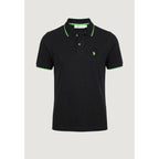 Front view of the black polo shirt with green accents, short sleeves, and collar on a solid color background.
