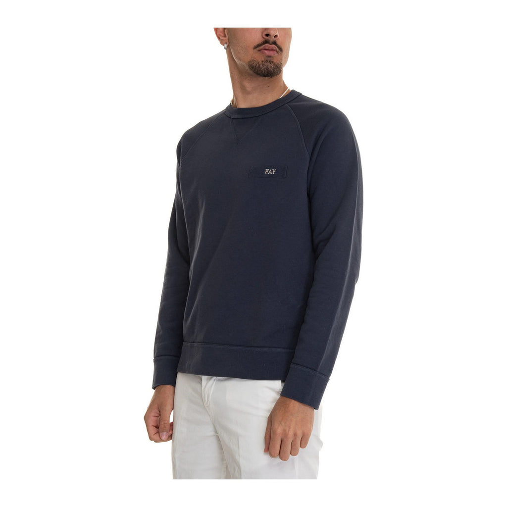 Lifestyle shot of a model wearing the navy sweatshirt with crew neck and long sleeves