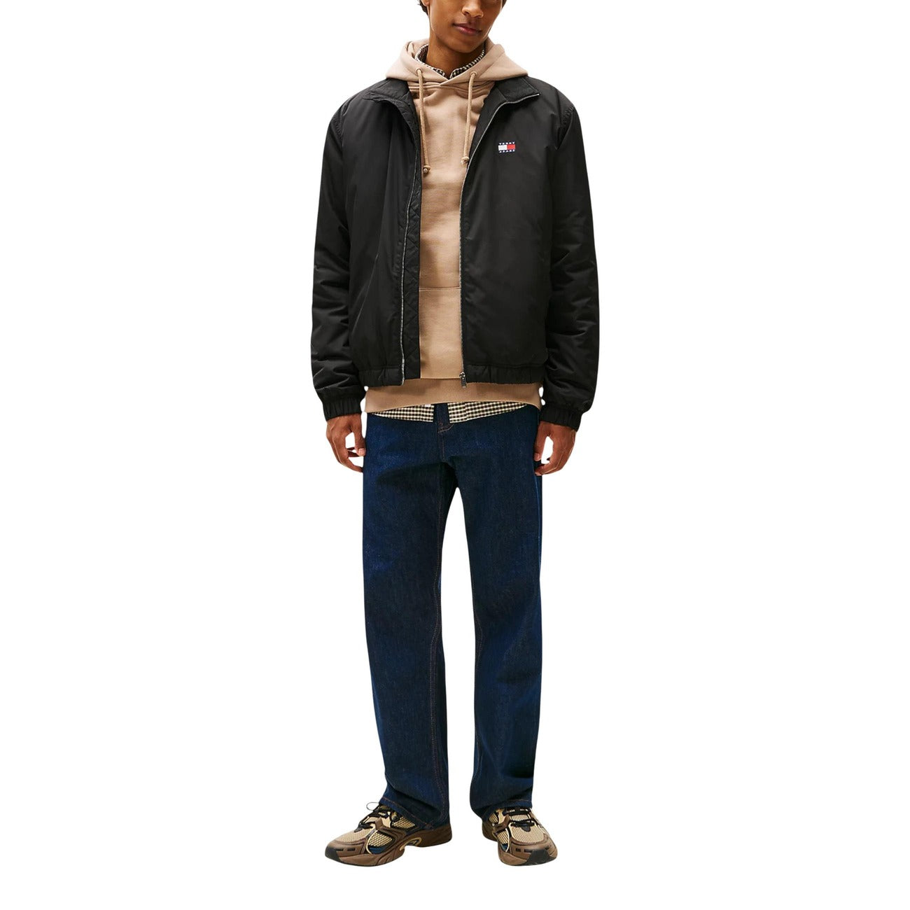 Lifestyle shot of a model in the black Tommy Hilfiger Jeans blazer styled with a casual outfit on a white background