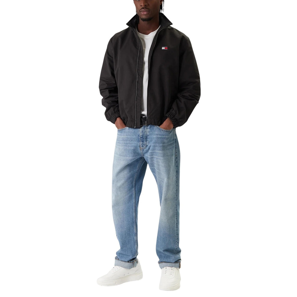 Lifestyle shot of the black blazer paired with jeans, showcasing a casual style on a white background