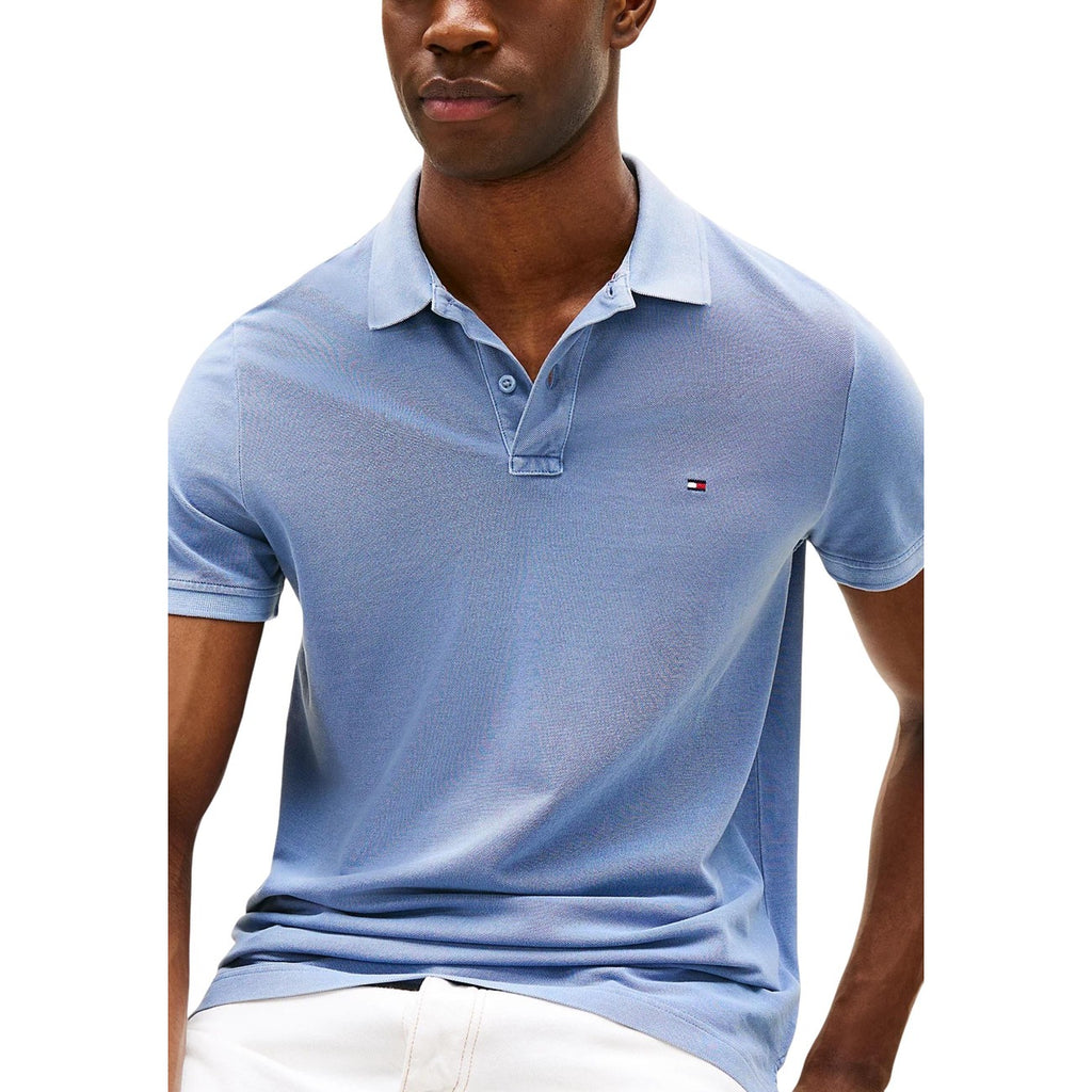 Detail close-up of the blue polo shirt showcasing the collar and logo on a white background.