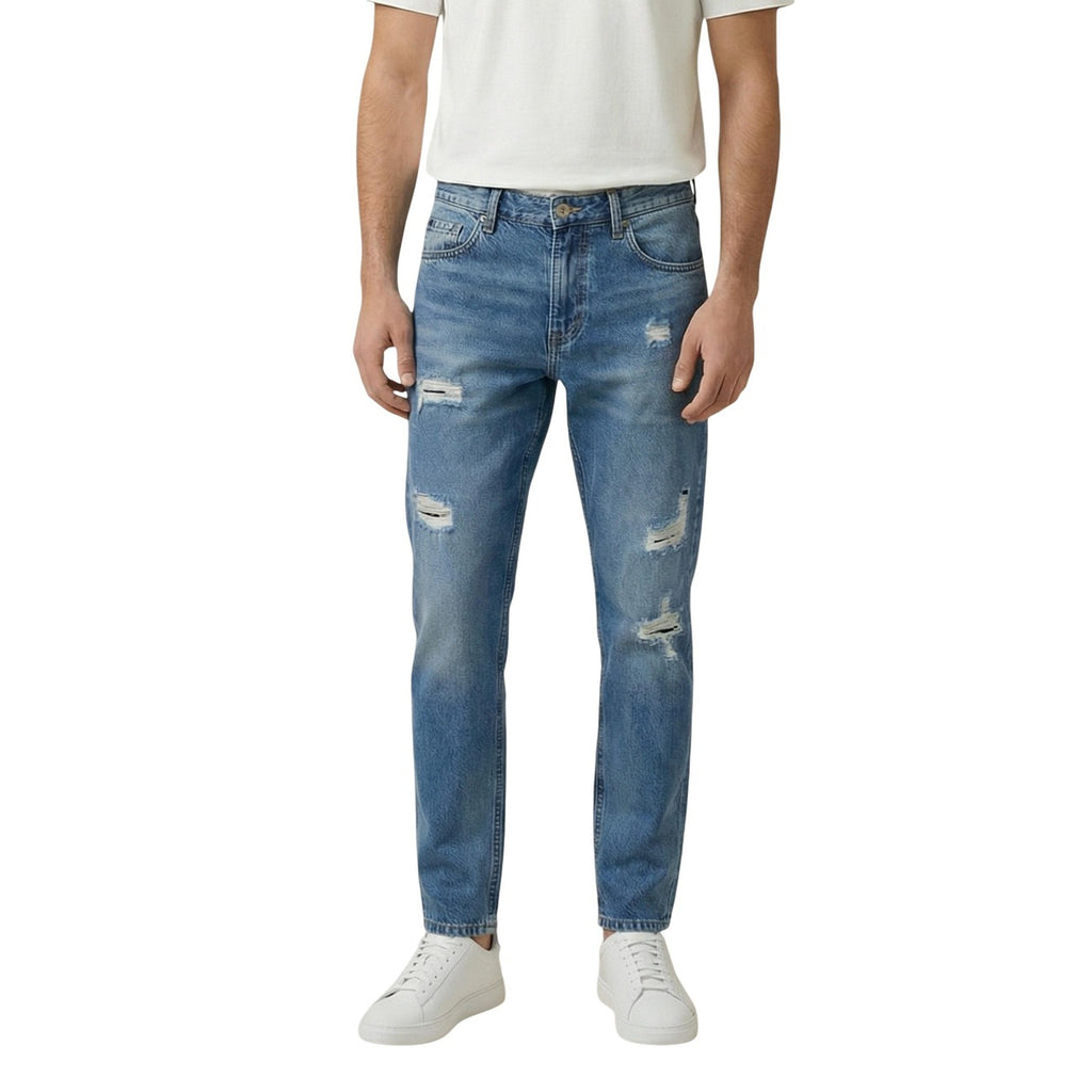 Lifestyle shot of distressed light blue jeans with a slim fit on a white background