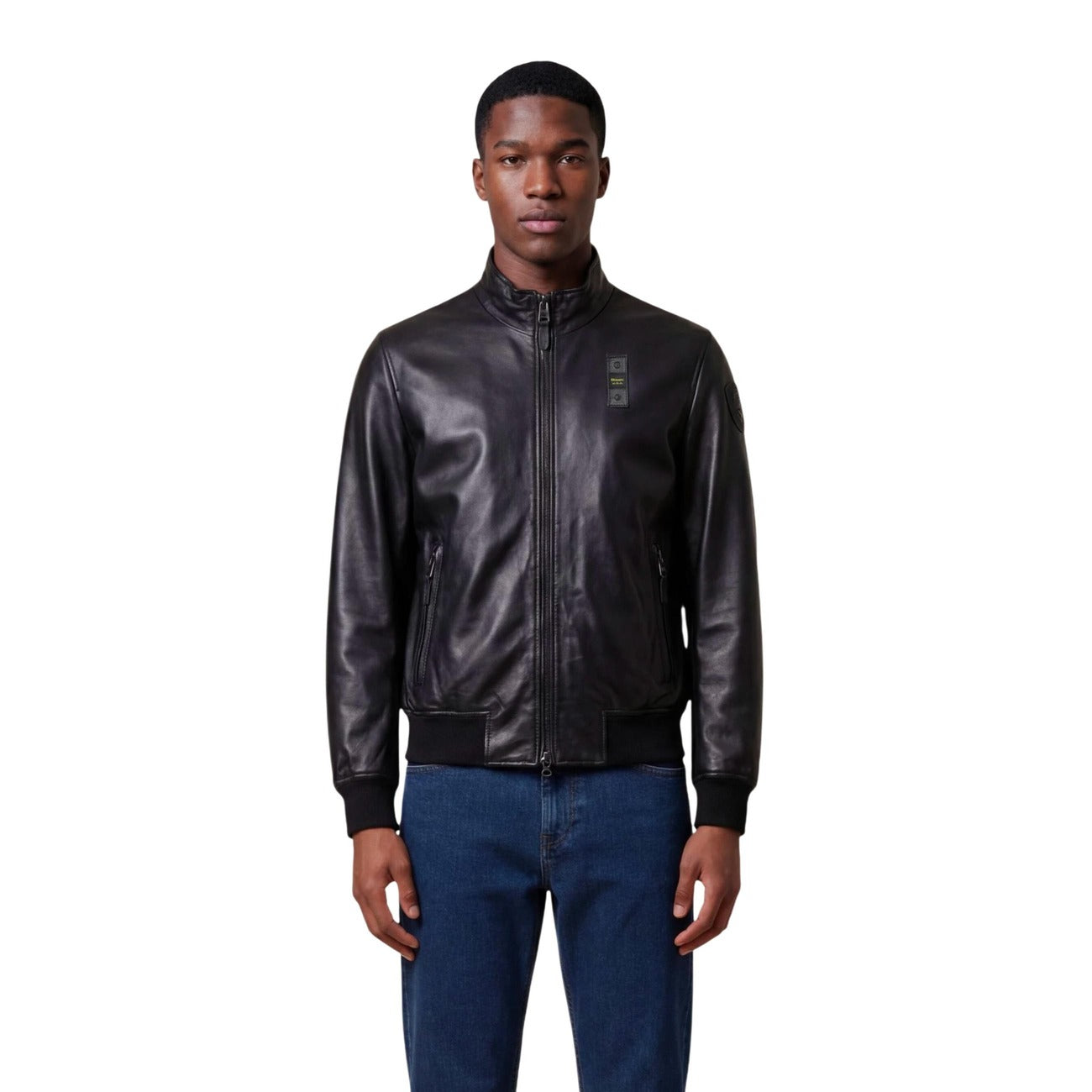 Lifestyle shot of a man wearing a fitted black leather blazer with zipper closure.