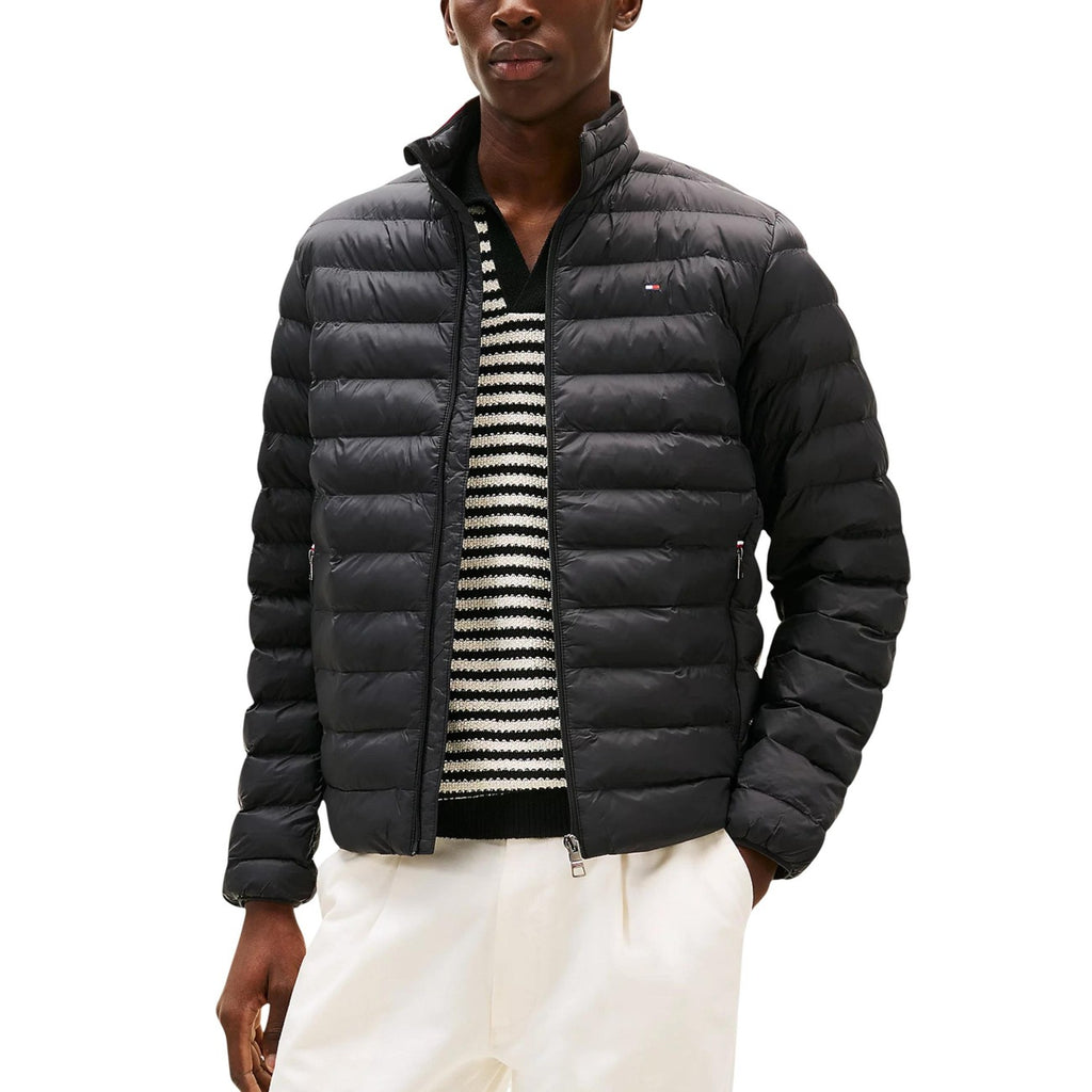 Detail shot of the black puffer jacket featuring a zipper closure and quilted design.