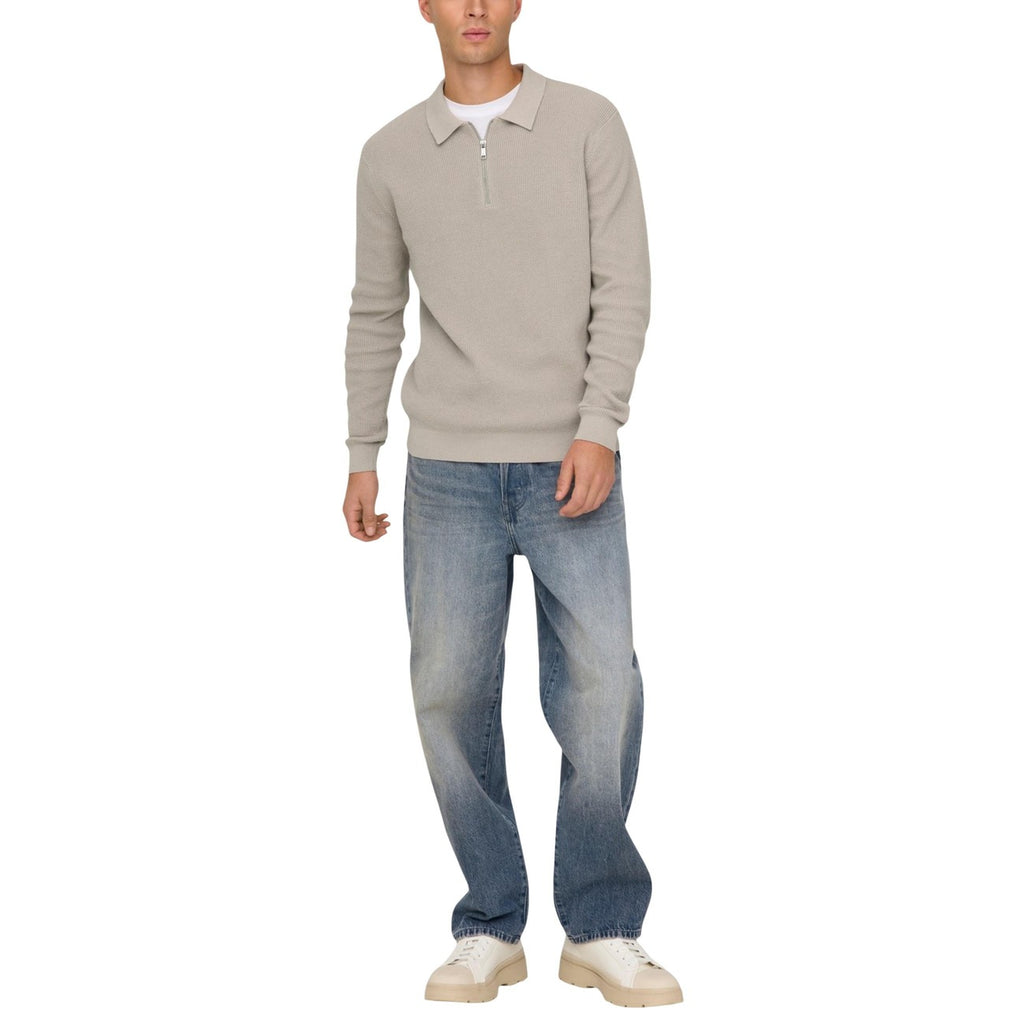 Lifestyle shot of a man wearing light blue faded denim jeans, loose fit, against a white background.