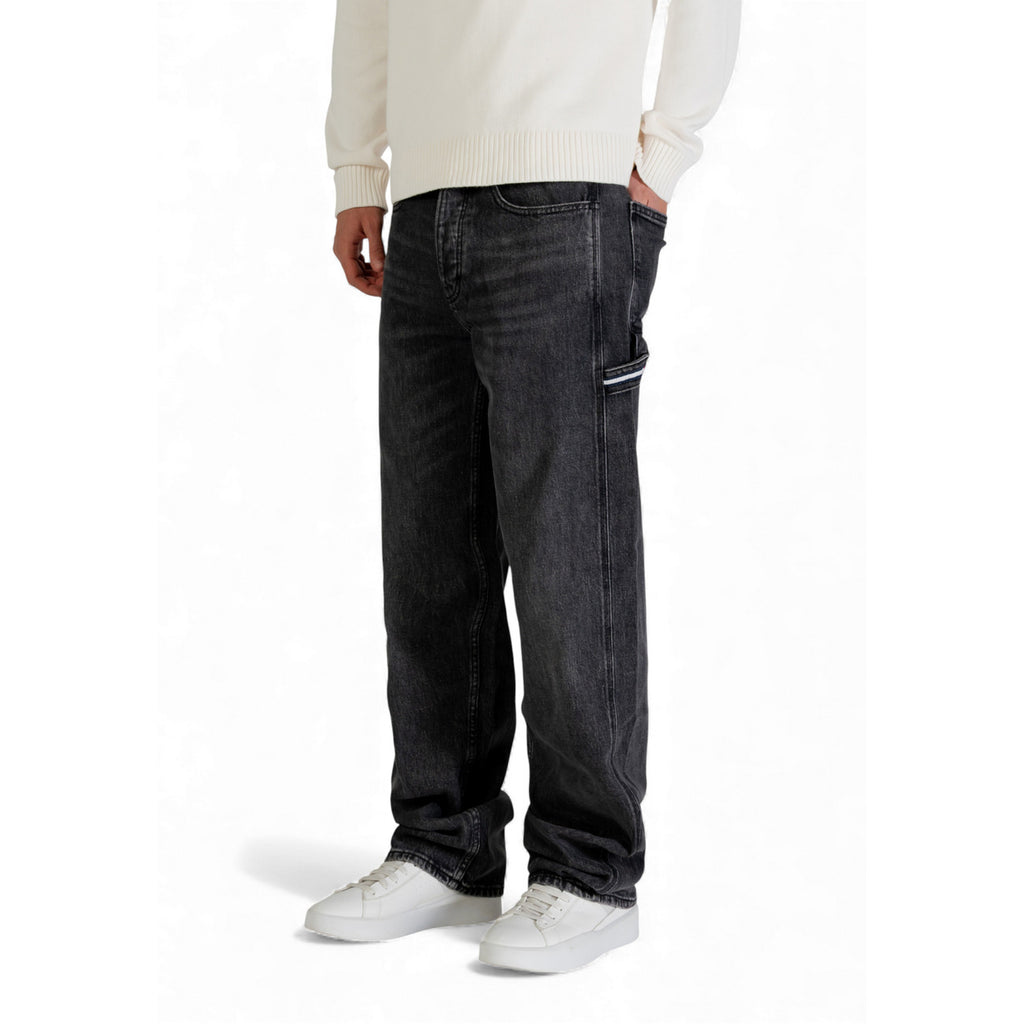 Side view of dark blue loose fit denim pants showcasing five pockets.