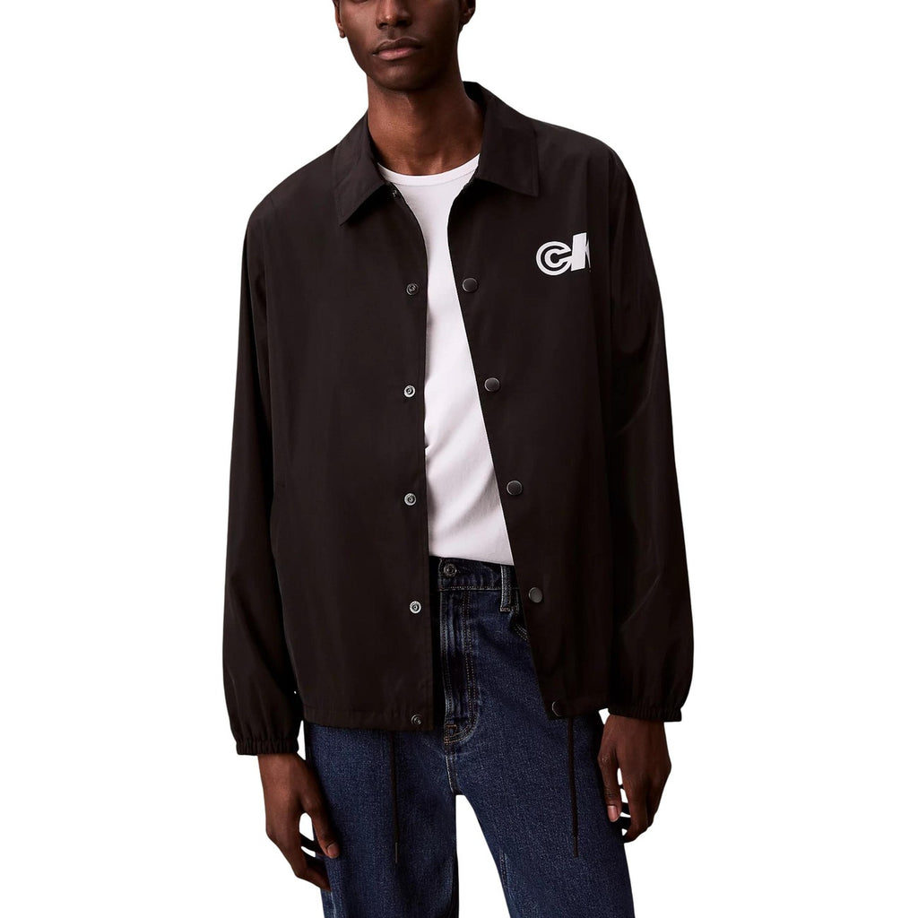 Lifestyle shot of a black blazer featuring button closure and logo patch on a white background.