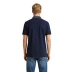 Back view of the navy polo shirt showcasing the collar and short sleeves against a white background.