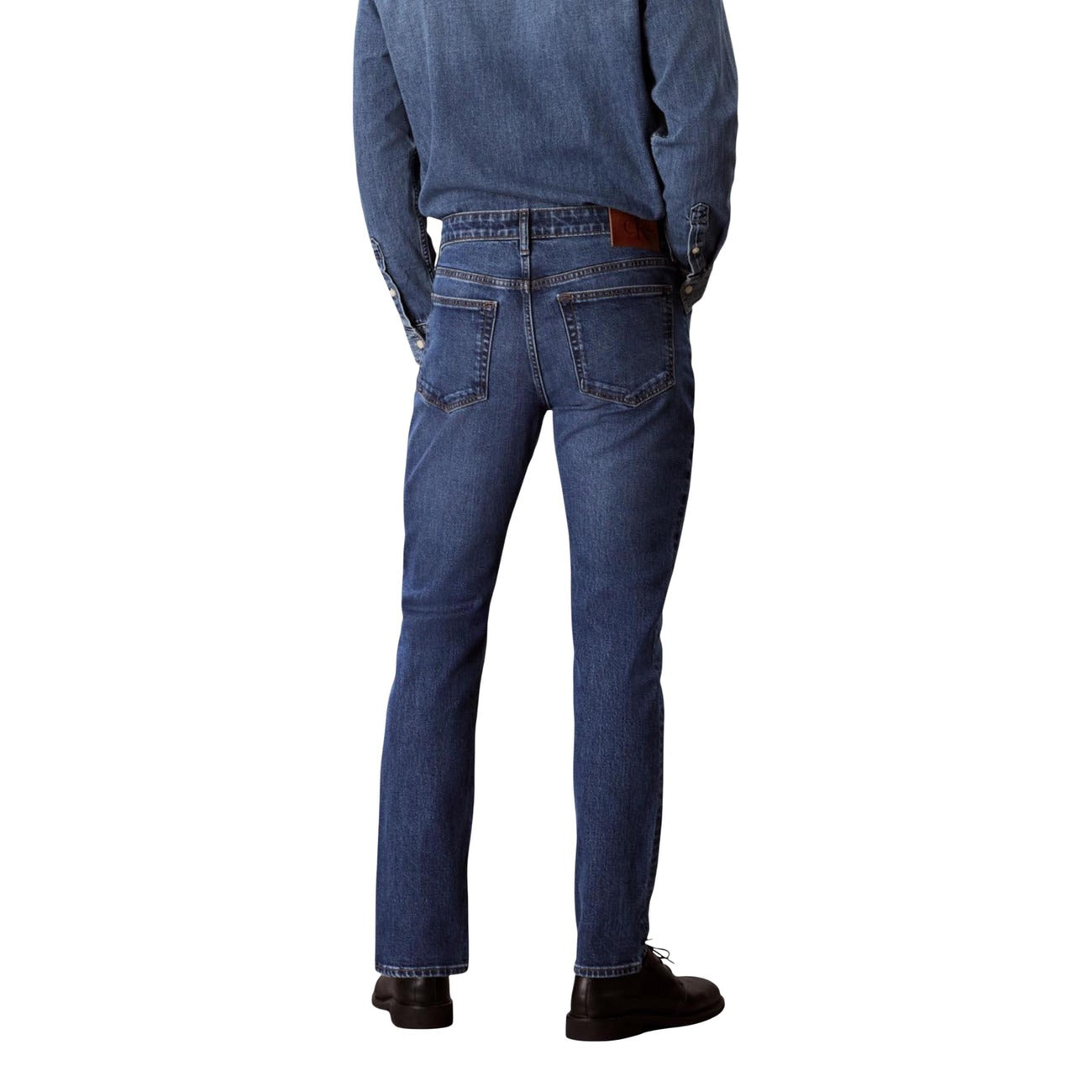 Side view of blue slim fit jeans with five pockets on a white background