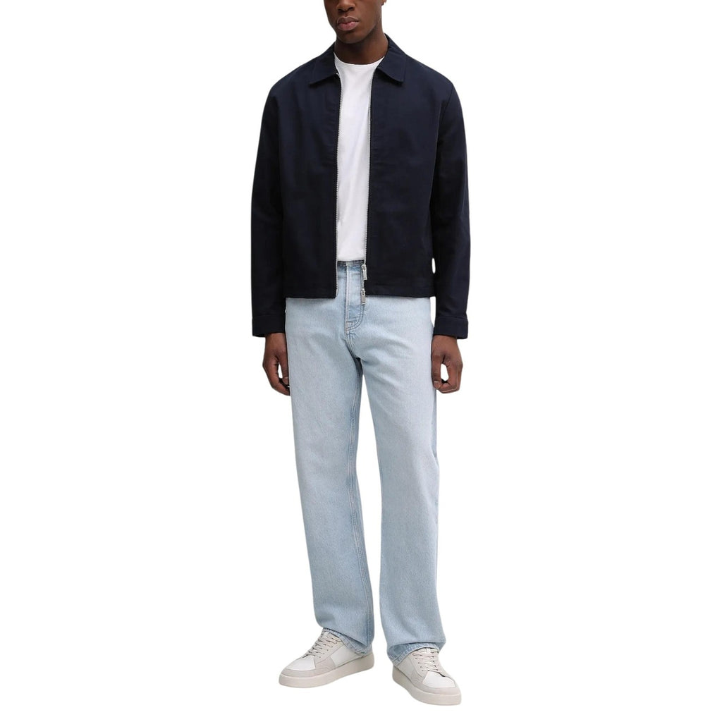 Lifestyle shot of the navy blazer paired with jeans and a white t-shirt on a white background.