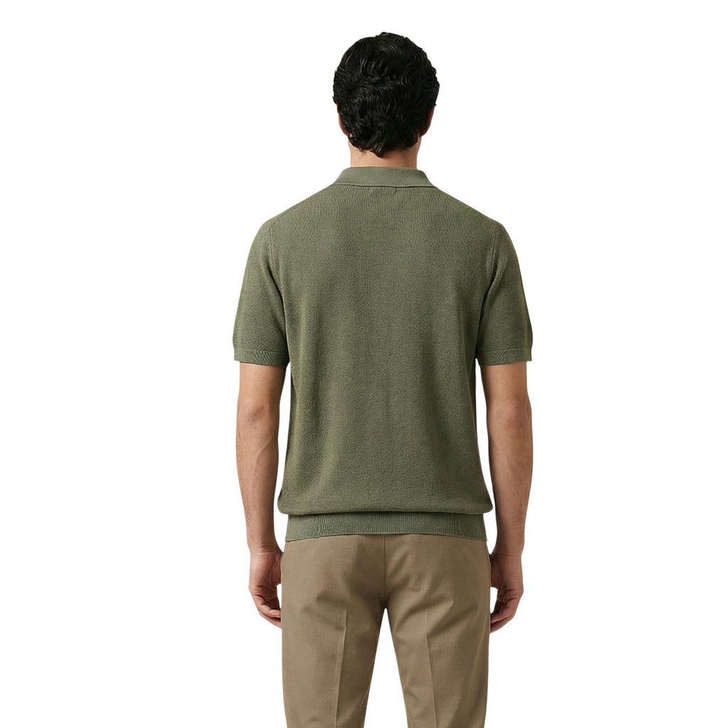 Back view of a man in a green polo shirt featuring short sleeves and collar against a white background.