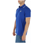Side view of the blue polo shirt showcasing the collar and logo with short sleeves on a white background