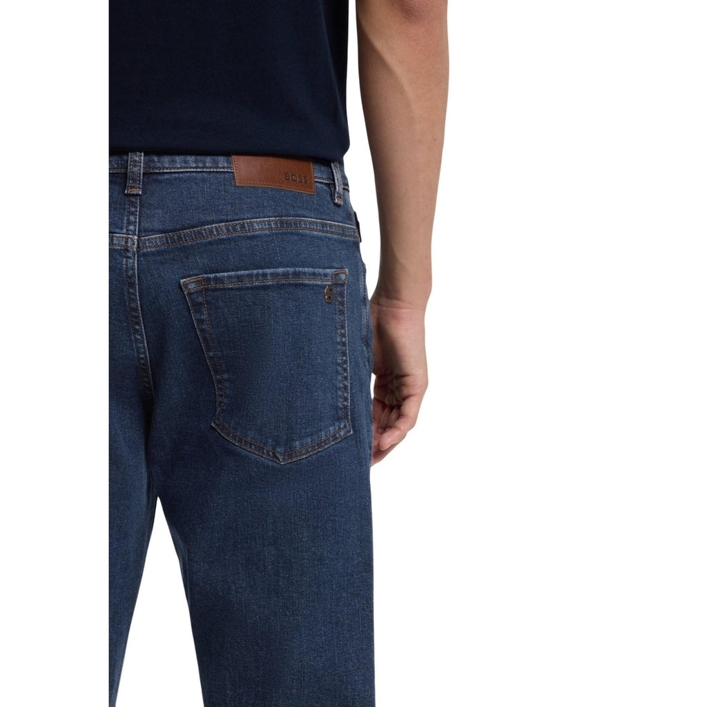 Back view of blue jeans showcasing back pockets and stitch detailing on a white background.