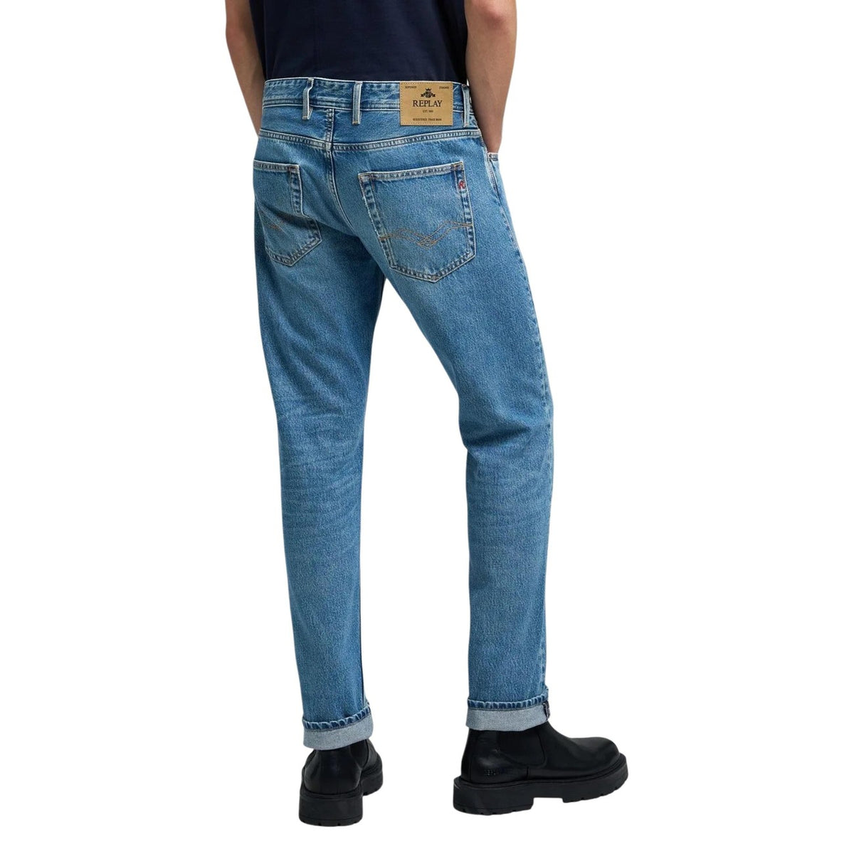 Lifestyle shot of blue jeans paired with a v-neck shirt on a white background