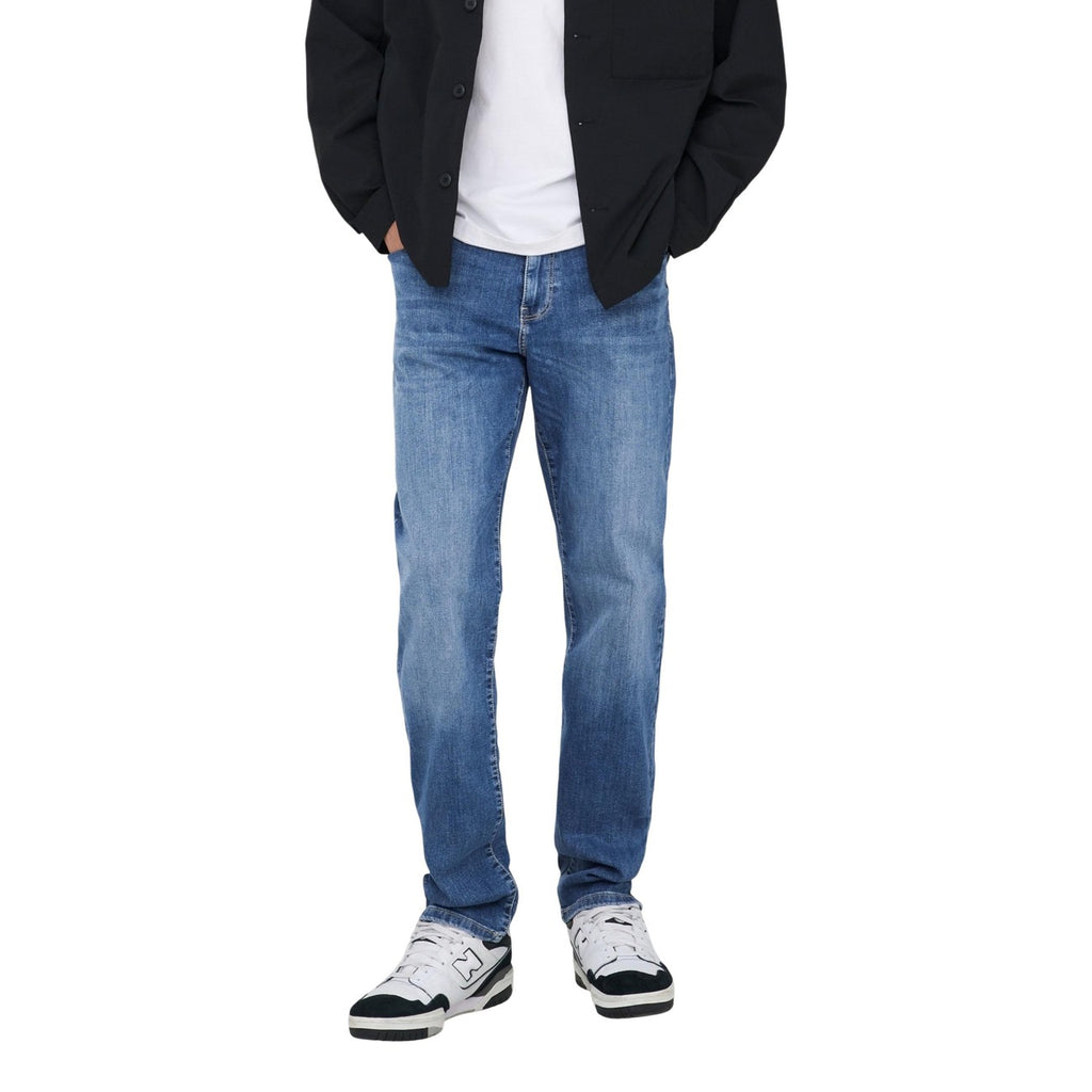 Lifestyle shot of light blue slim fit jeans with a faded wash against a white background