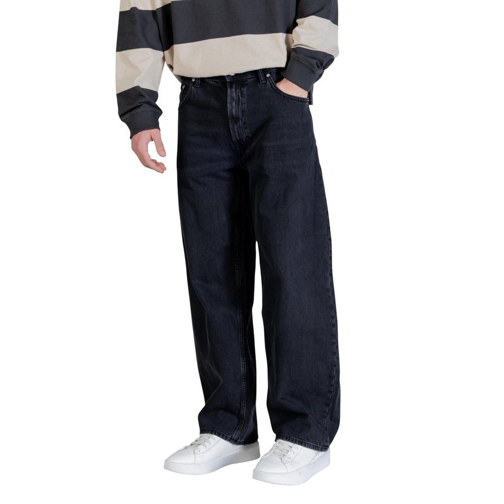 Side view of black wide leg jeans featuring front pockets on a white background