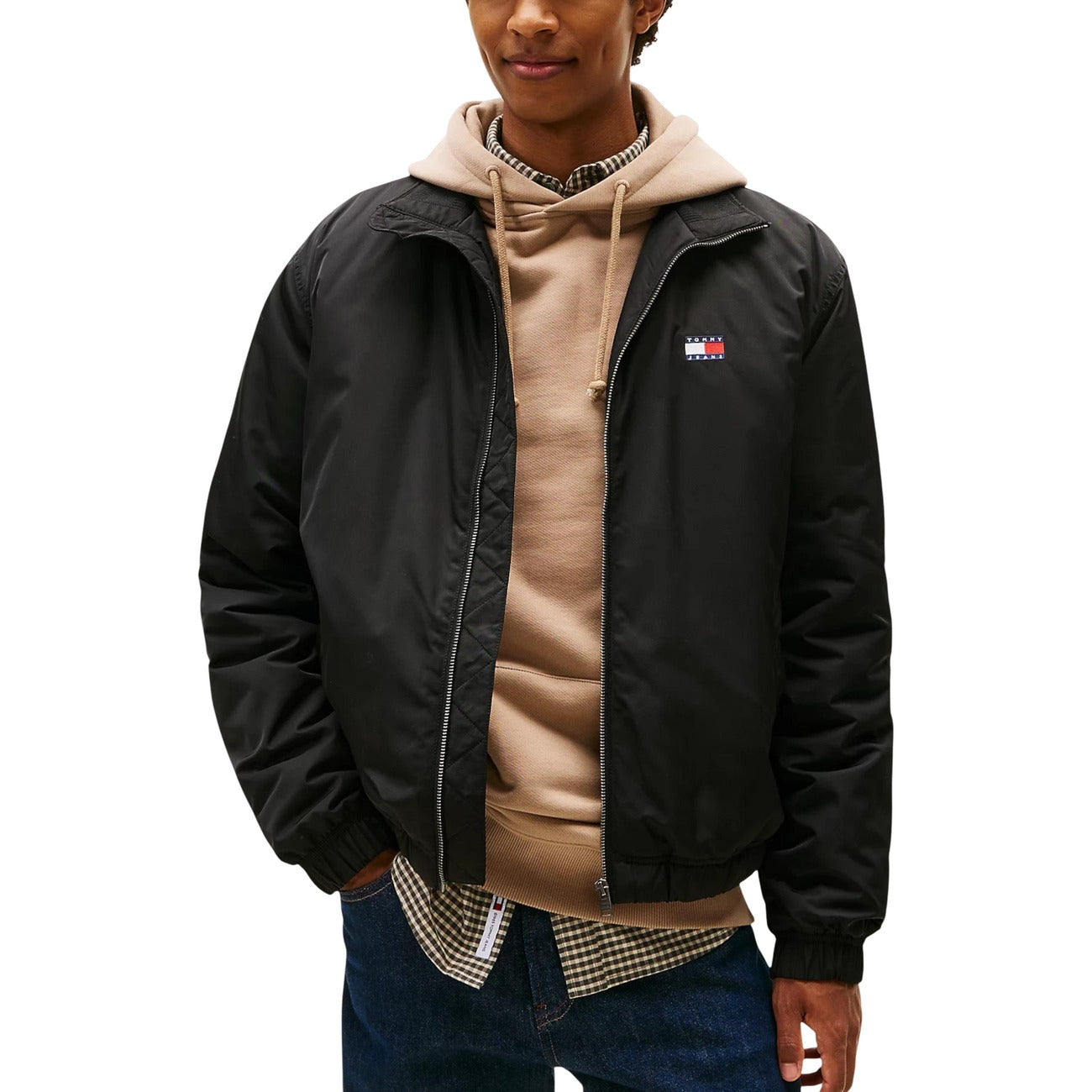 Lifestyle shot of a model wearing the black Tommy Hilfiger Jeans blazer with a hoodie underneath against a white background