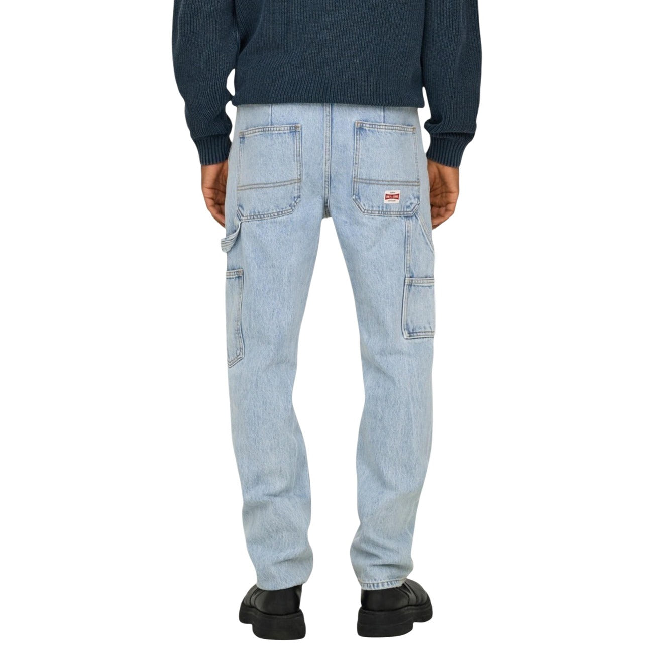 Lifestyle shot of light blue jeans in a casual style against a white background