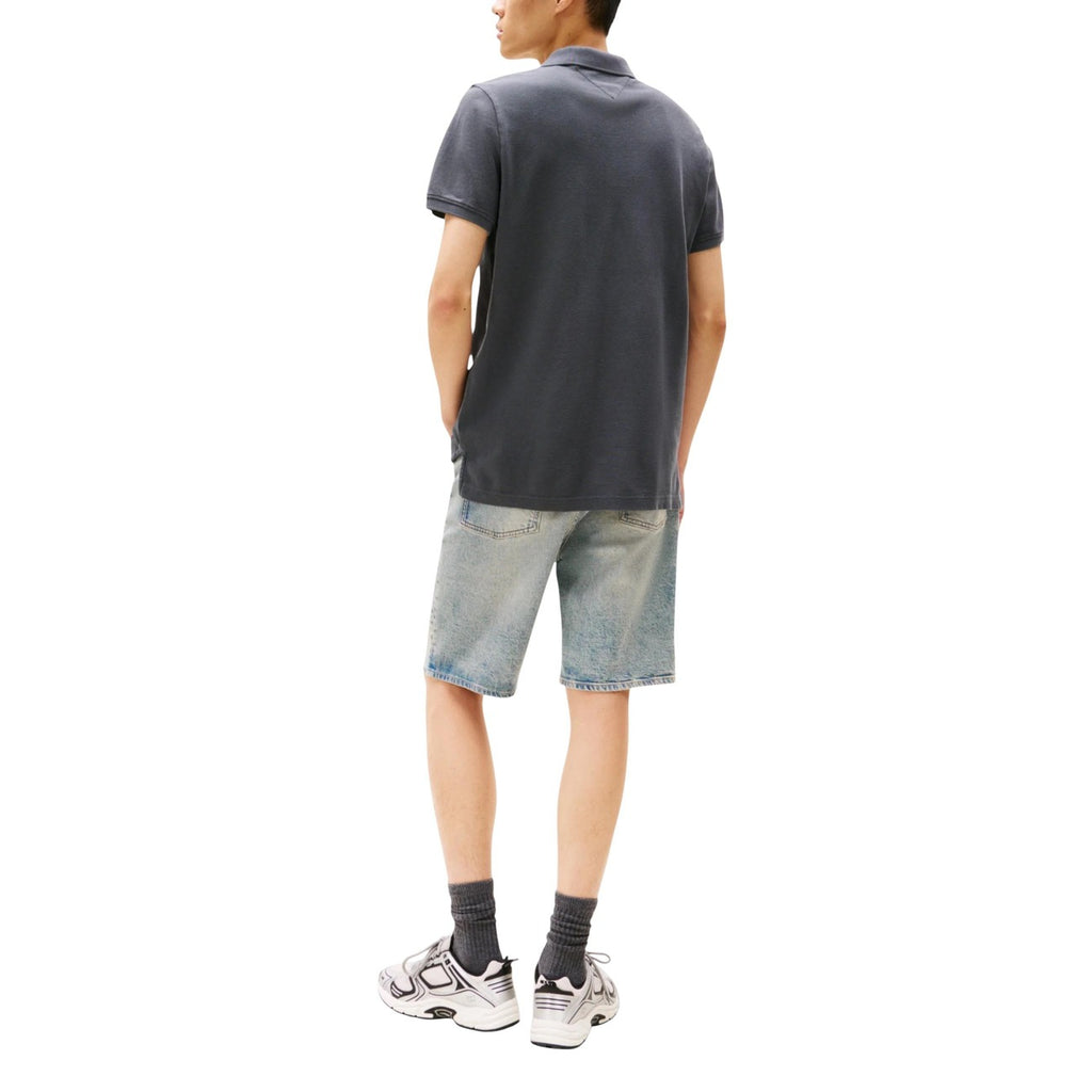 Lifestyle shot of a man in a gray polo and denim shorts, showcasing a casual look.