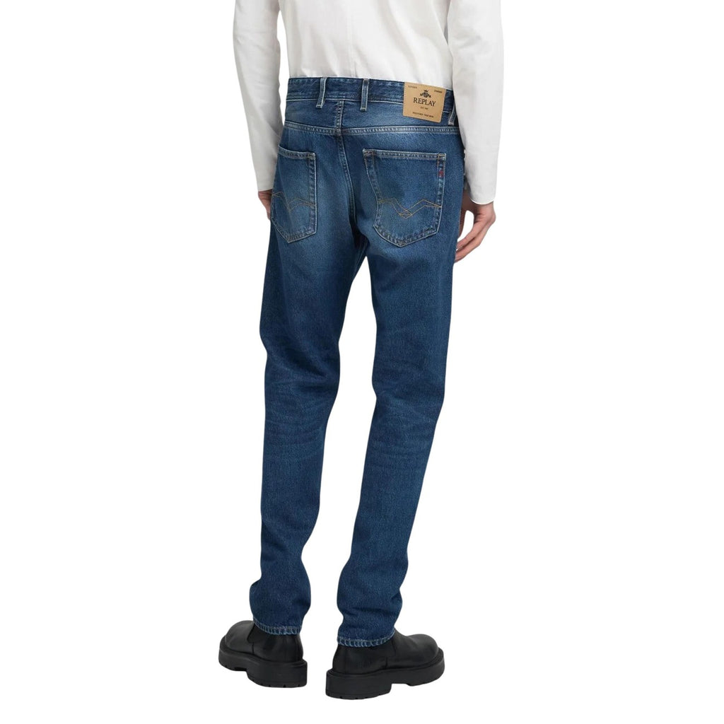 Back view of blue jeans showing pocket detail and brand logo on a white background