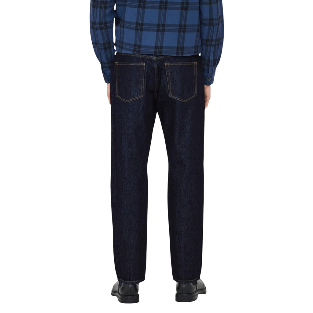 Back view of a man in a plaid shirt wearing blue jeans, highlighting the back pockets.