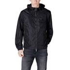 Front view of the black hooded jacket featuring a zipper closure and pockets against a white background.