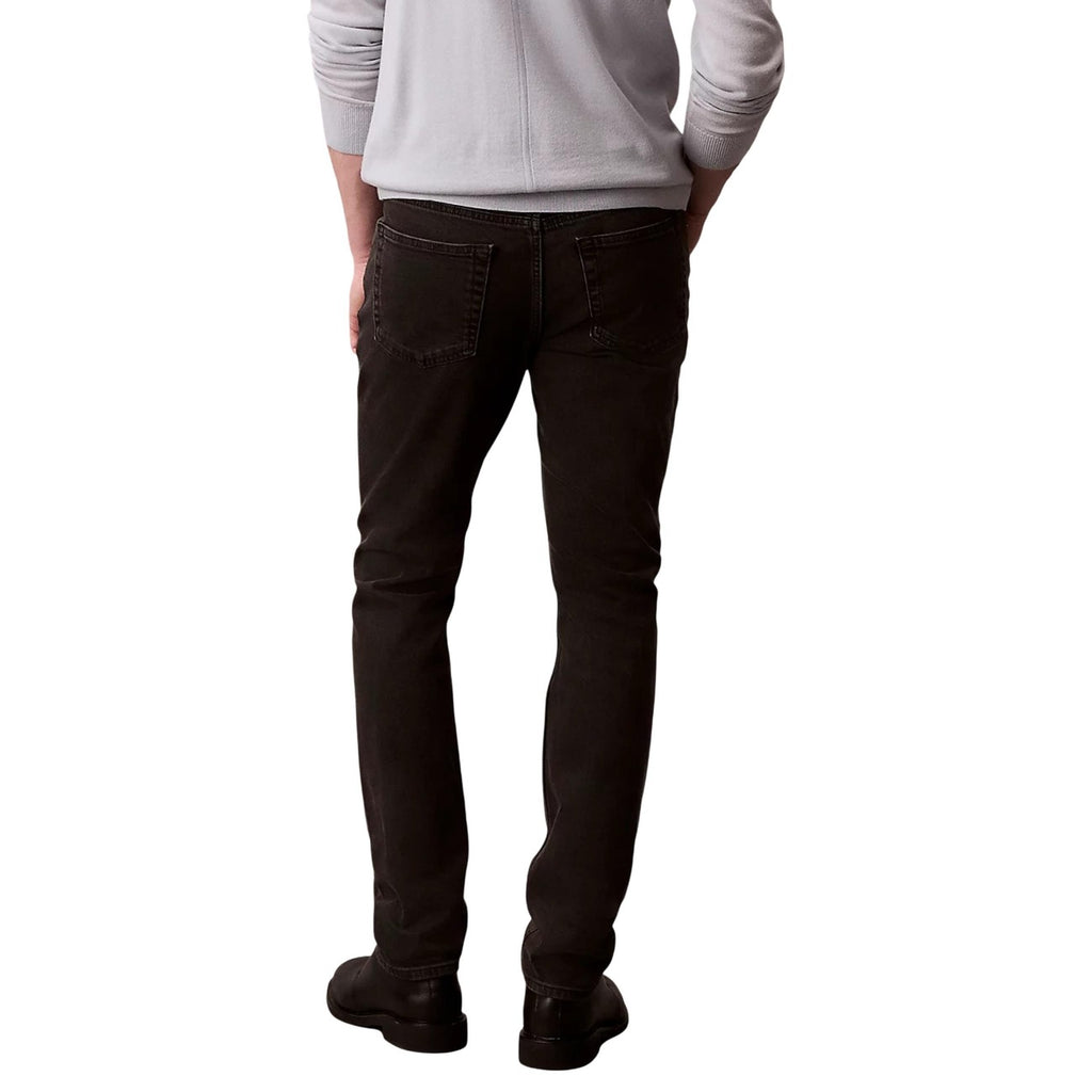 Back view of the black jeans showcasing slim fit and pocket details on a white background