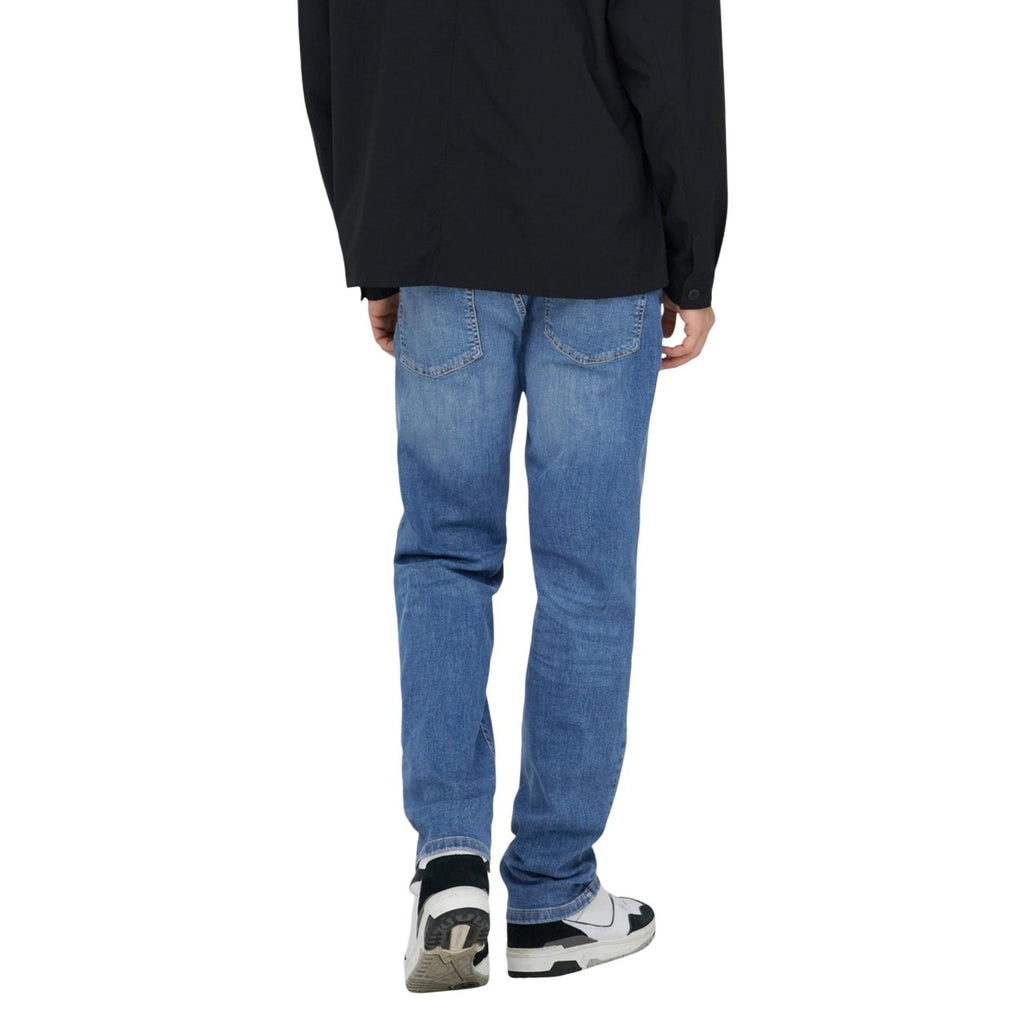 Back view of light blue slim fit jeans featuring a faded wash on a white background