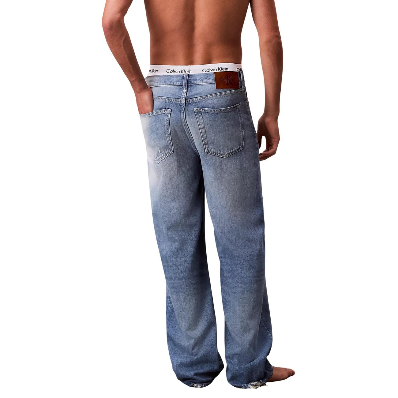 Back view of blue wide leg jeans with light wash on a white background