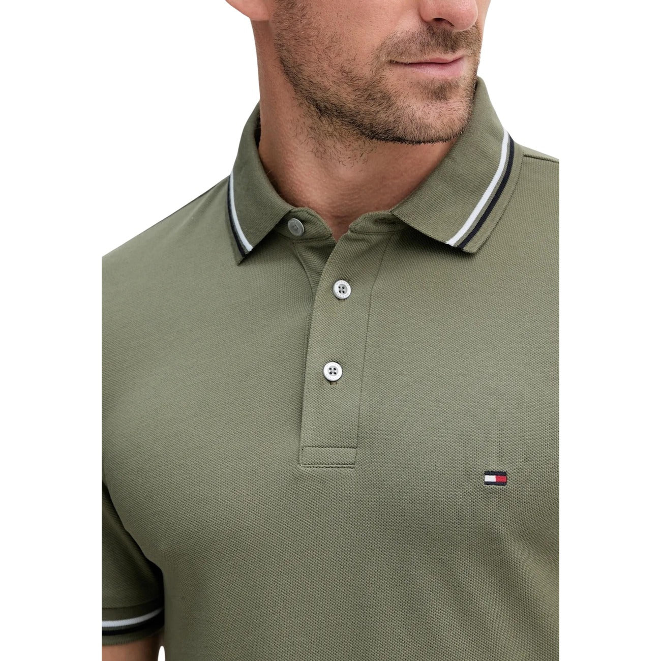 Close-up detail of a green polo shirt showcasing the collared design and logo on a white background.