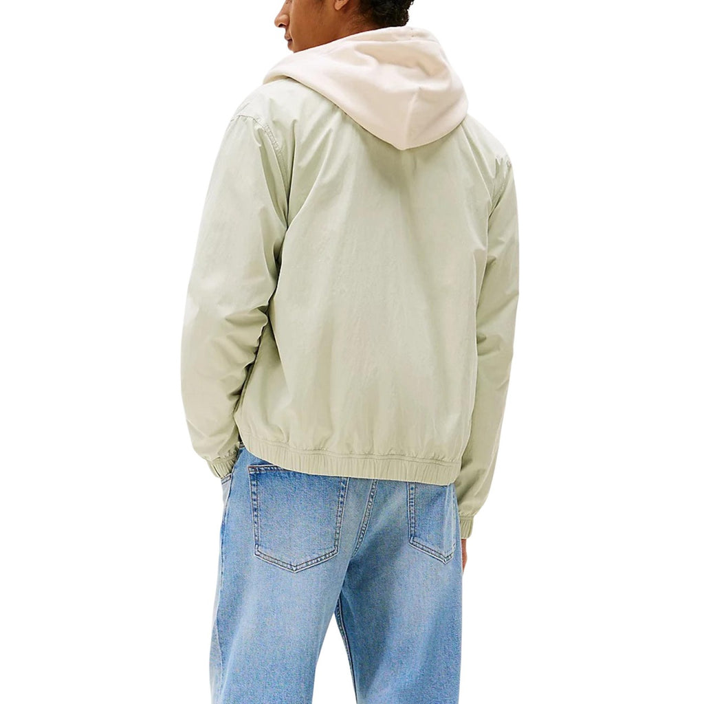 Back view of a light green casual fit jacket on a white background