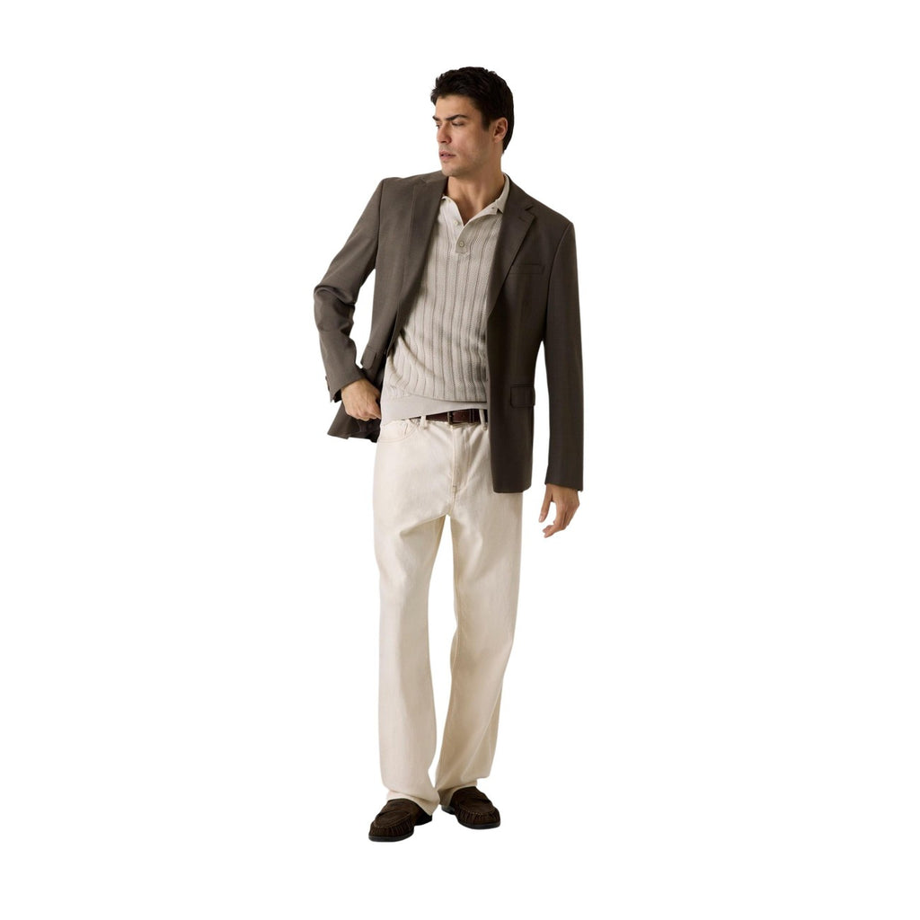 Lifestyle shot of a man in a brown blazer and beige dress pants on a white background.