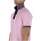 Side view of the pink polo shirt showcasing the button placket and short sleeves.