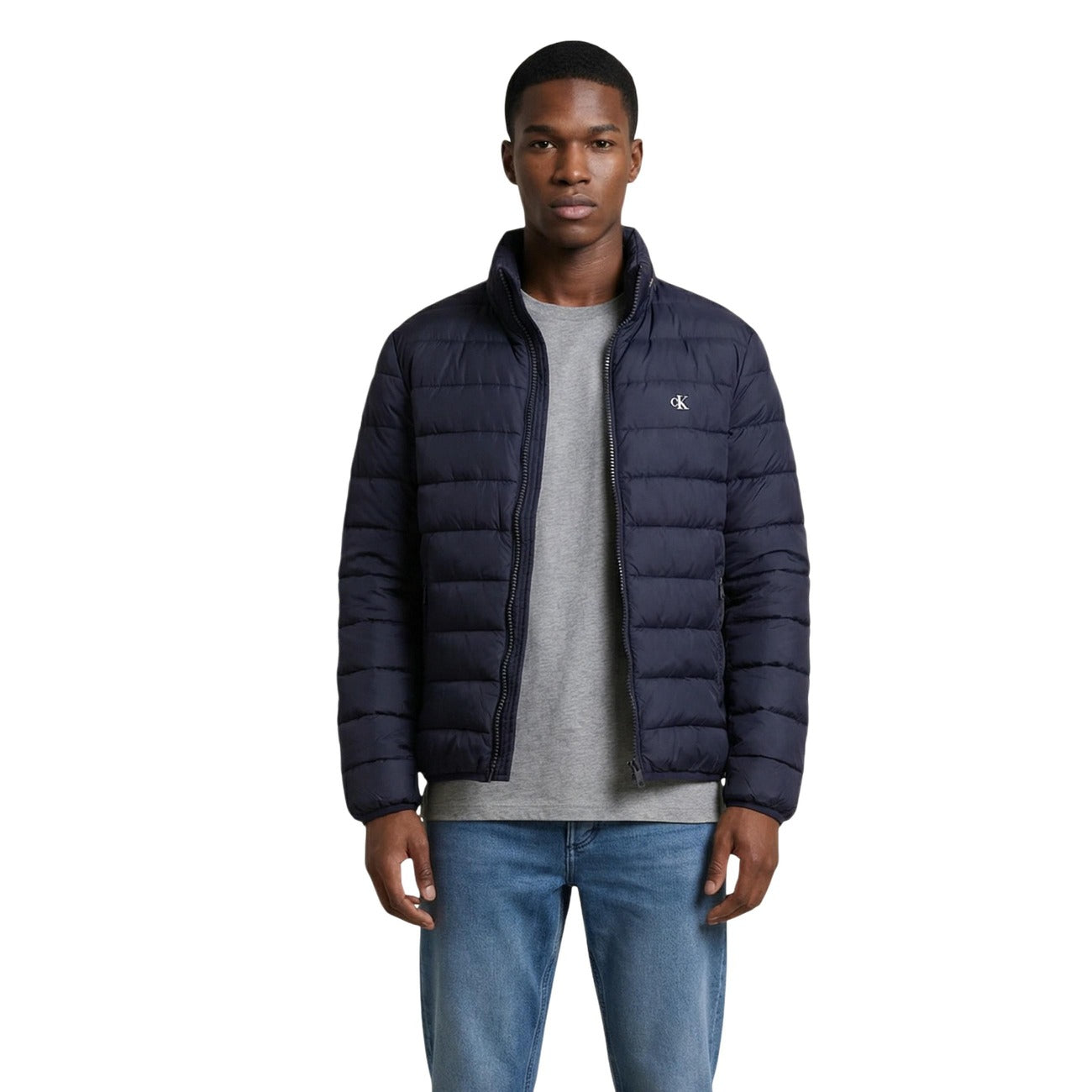 Front view of the navy puffer jacket featuring a zipper closure and quilted design on a white background