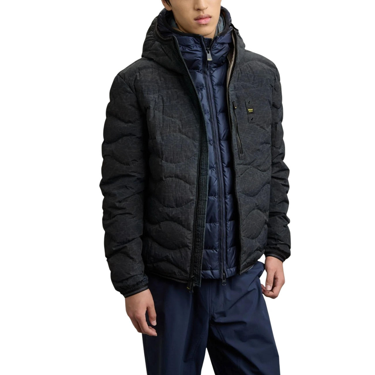 Lifestyle shot of a man wearing the black puffer jacket with a hood.