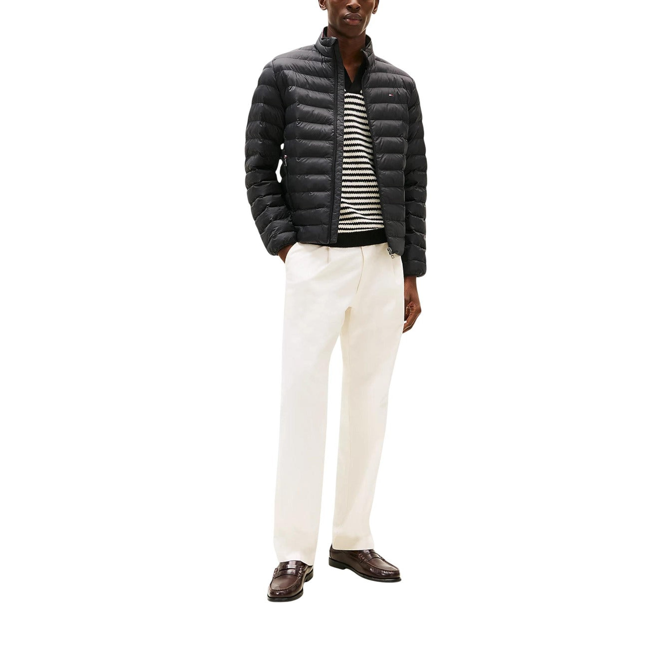 Lifestyle shot of a man wearing a black puffer jacket with zipper closure and quilted design.