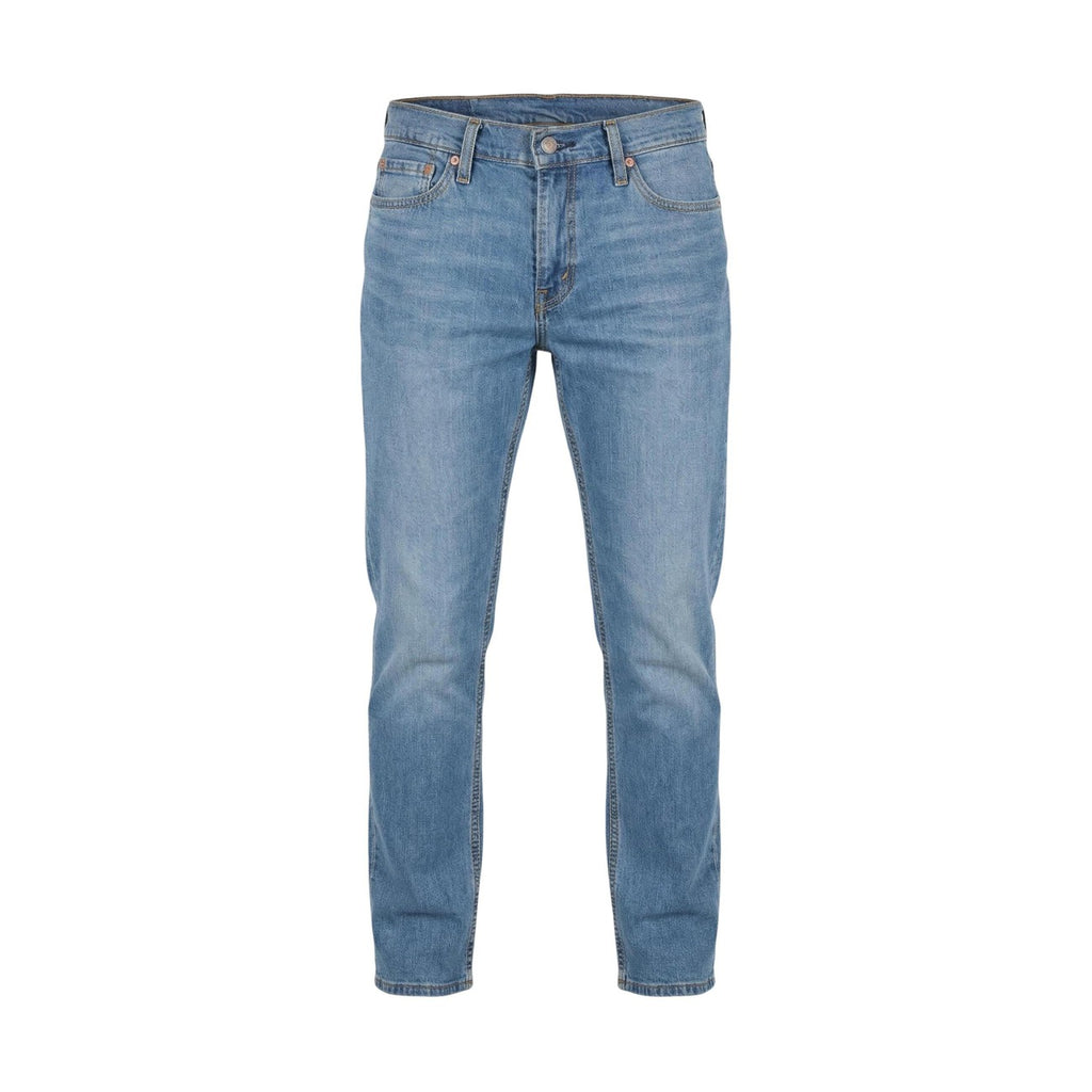Detail close-up of blue denim jeans with button closure on a white background