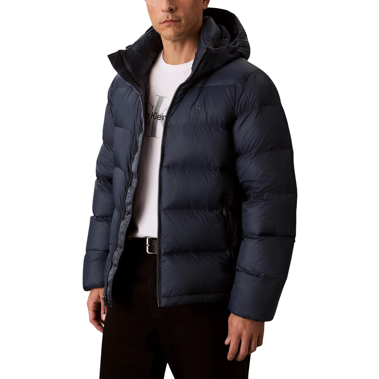 Lifestyle shot of a navy puffer jacket featuring a hood and zipper closure against a white background.